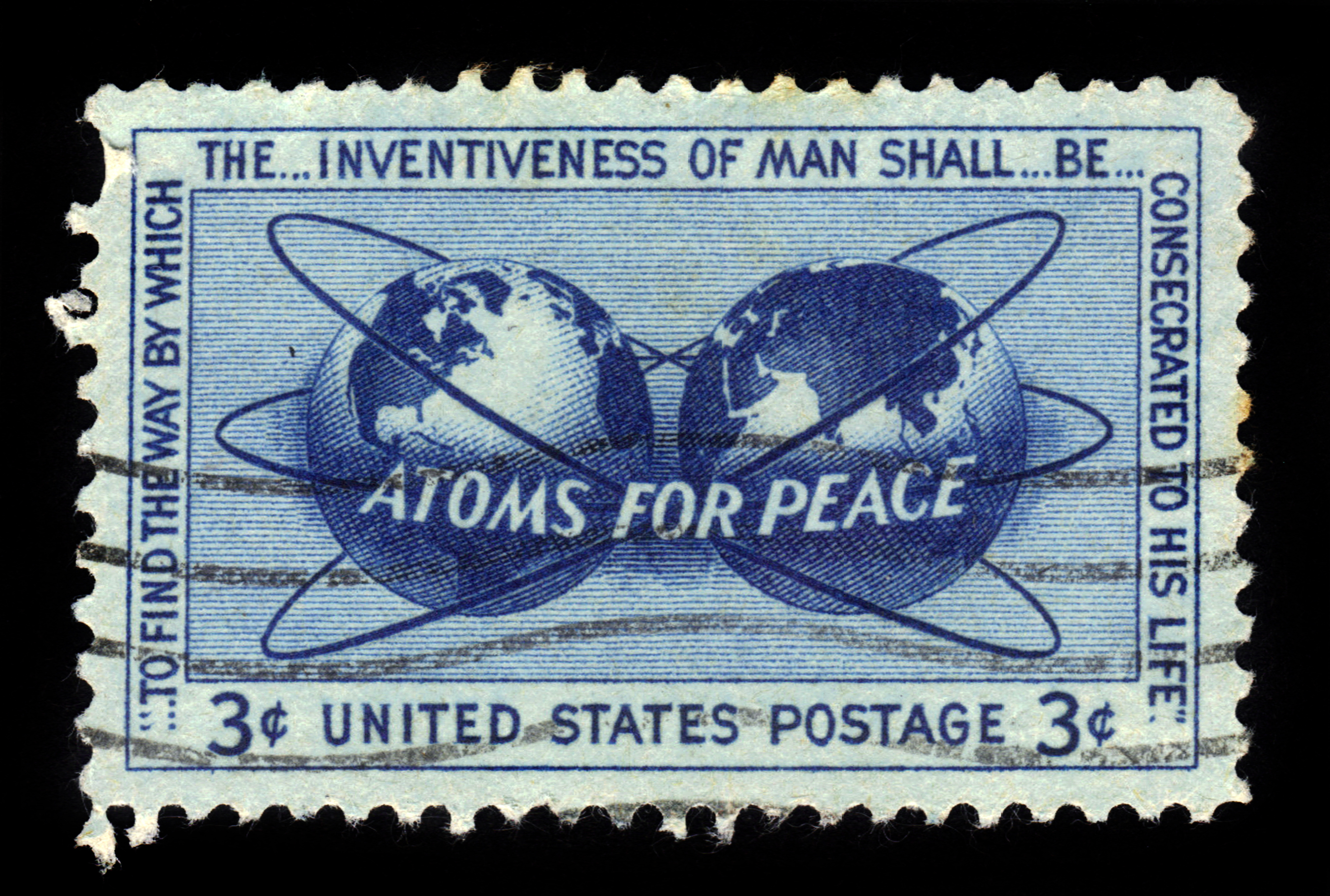 A blue 3-cent US postage stamp featuring two globes, atomic orbits, and the words “ATOMS FOR PEACE,” with additional text promoting the peaceful use of atomic energy.