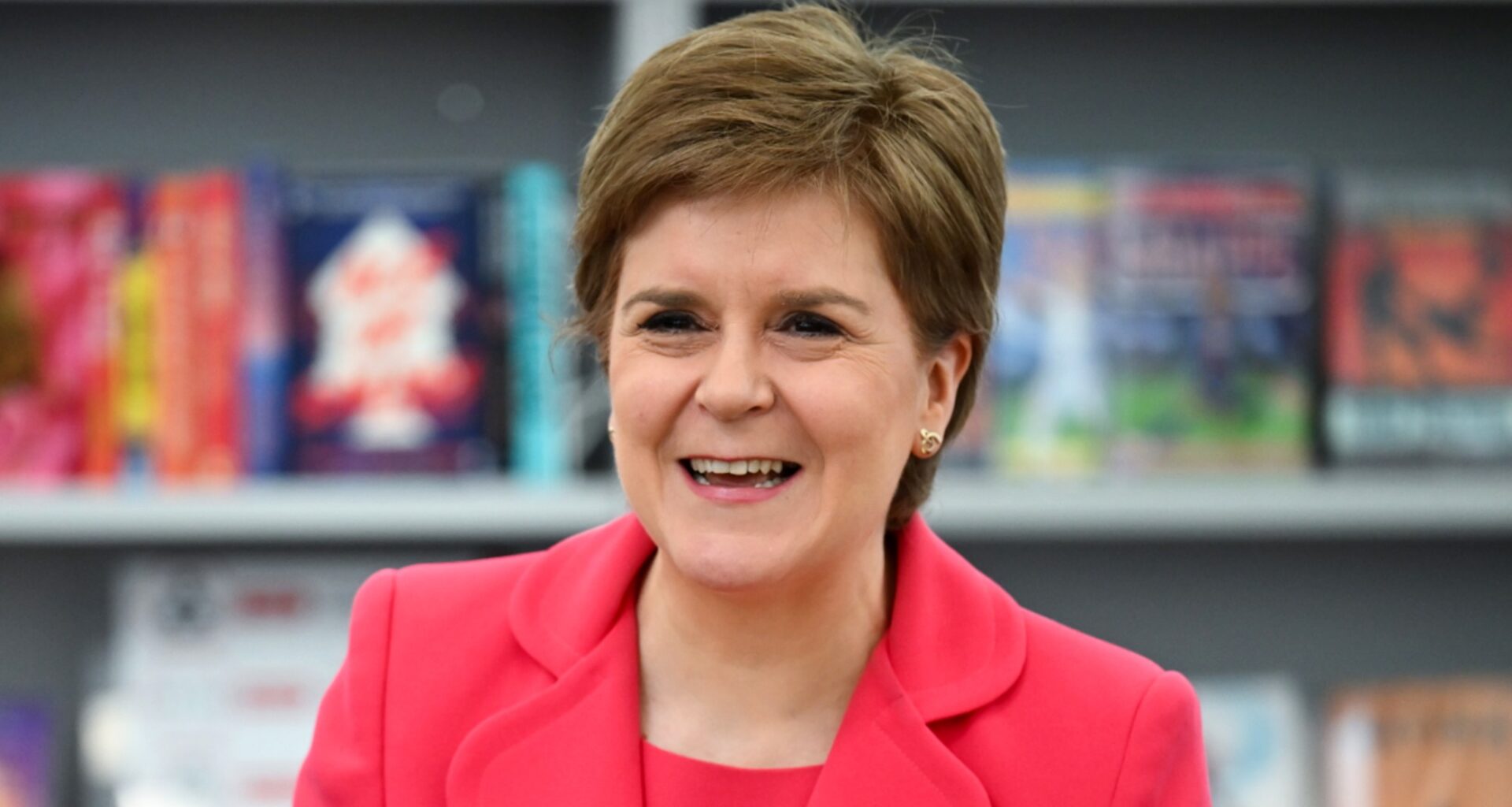Nicola Sturgeon stands in front of books at a school in Prestwick, Scotland