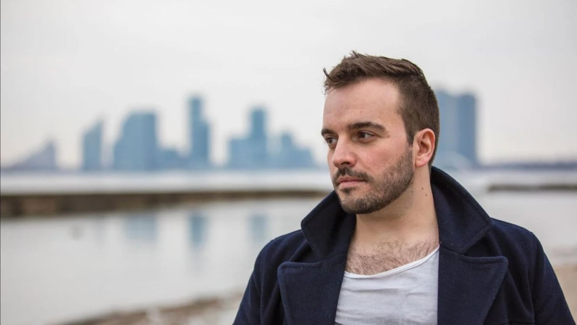 A man with short brown hair looking to the right side of the screen. 