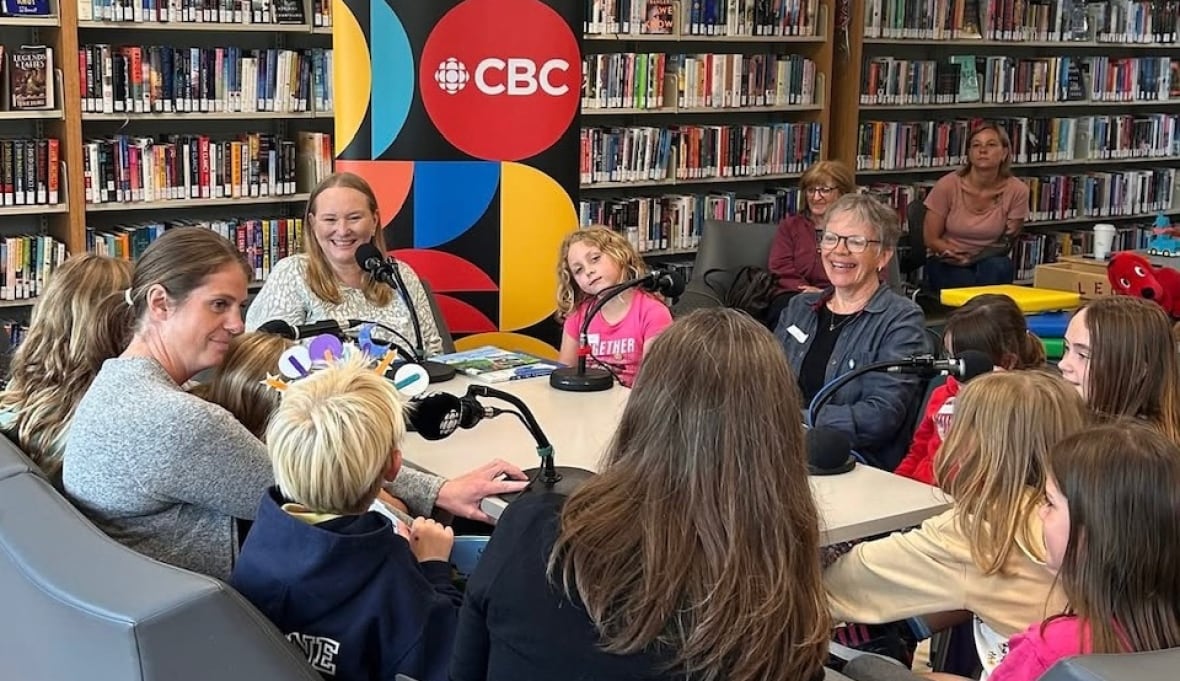 woman sitting around table with children