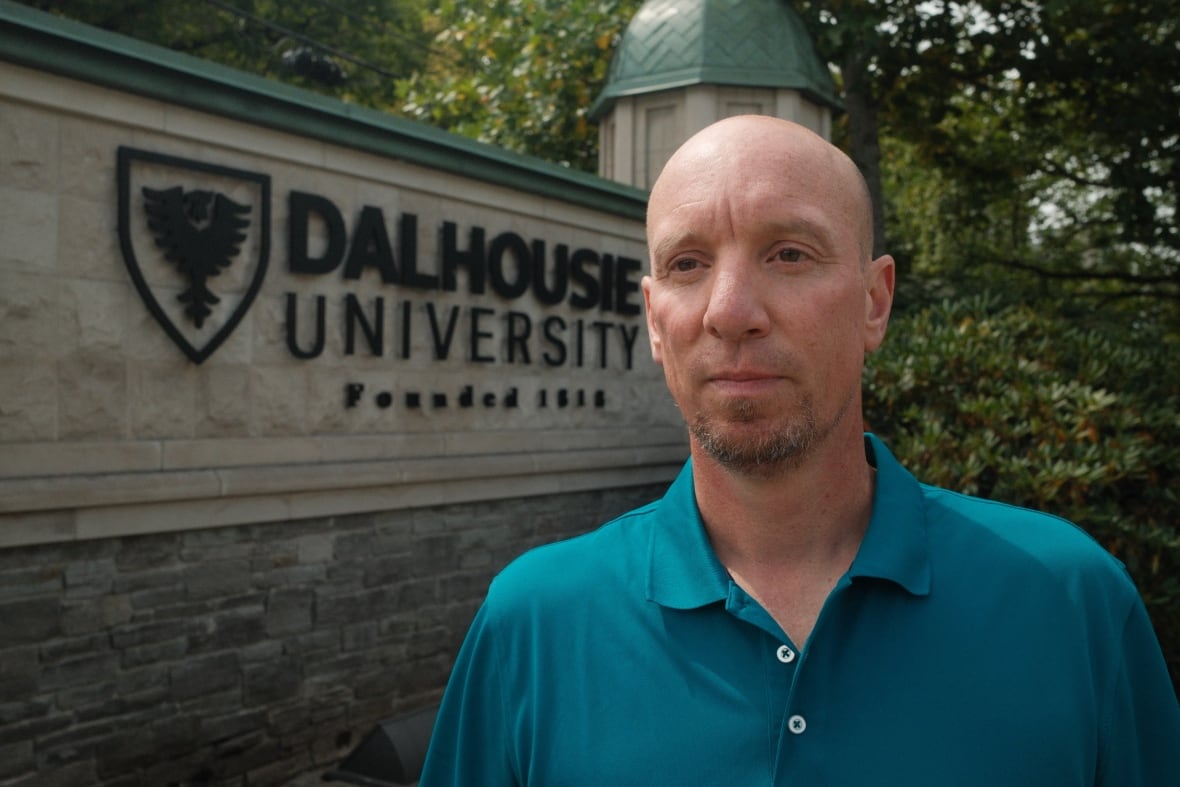 A man is shown by a sign that says 'Dalhousie University.'