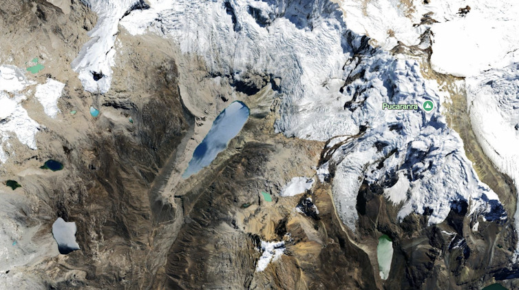 A satellite view of a large glacial lake at the edge of a deep valley.