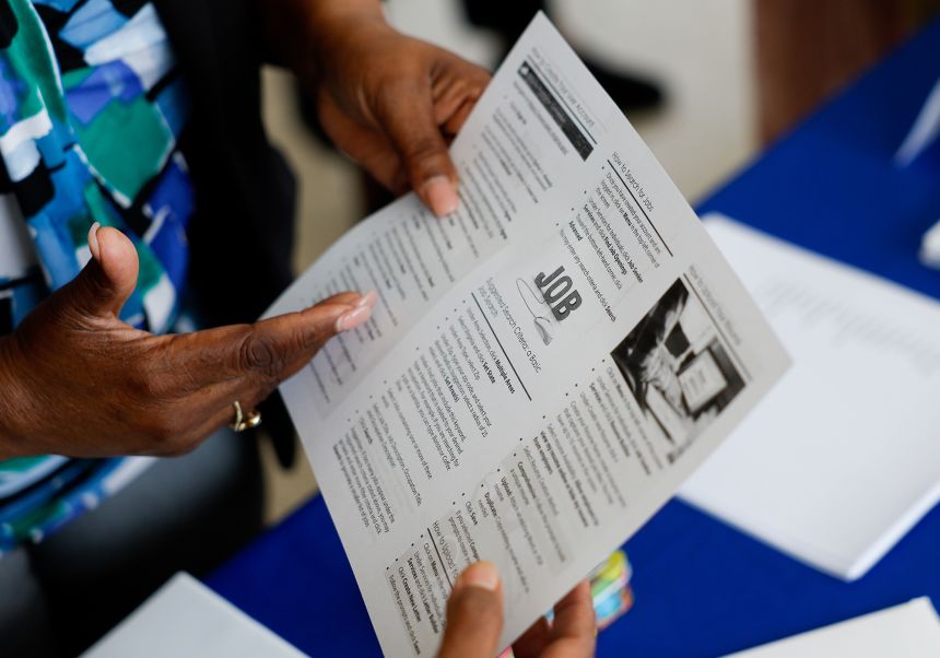 A recruiter shows a pamphlet during a job fair hosted by the Metropolitan Washington Airports Authority to support federal workers looking for new career opportunities, at Ronald Reagan Washington National Airport (DCA) in Arlington, Virginia, on April 25.