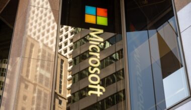 Microsoft logo and multicolour window emblem on reflective glass facade of downtown office tower, San Francisco