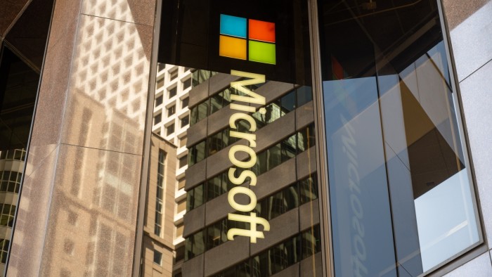 Microsoft logo and multicolour window emblem on reflective glass facade of downtown office tower, San Francisco
