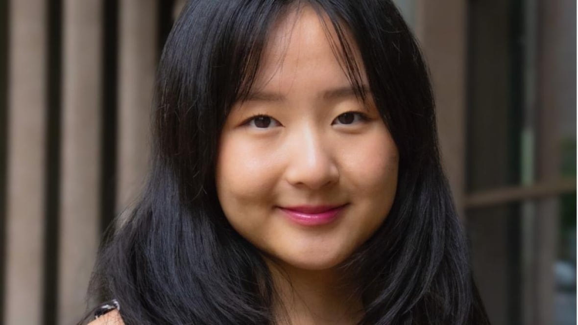 A woman with long black hair smiling at the camera. 