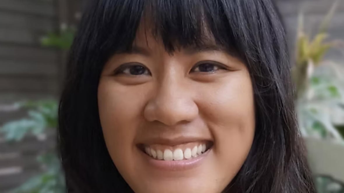An Asian woman is smiling at the camera. 