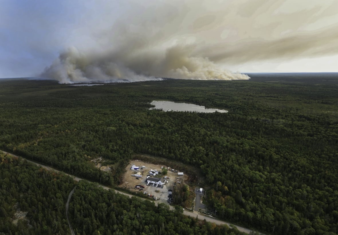 An aerial photo shows the West Dalhousie Community Centre, which is serving as the incident command post for the wildfire. Smoke from the Long Lake fire can be seen in the background.