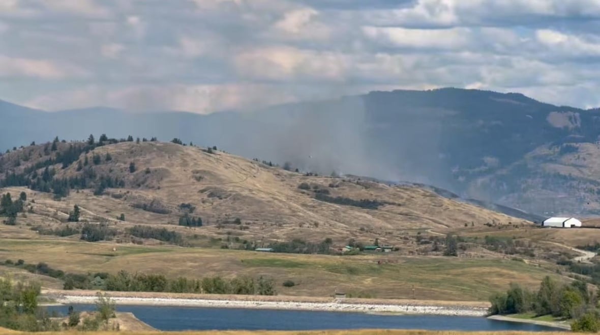Smoke billows up from a wildfire on a hill