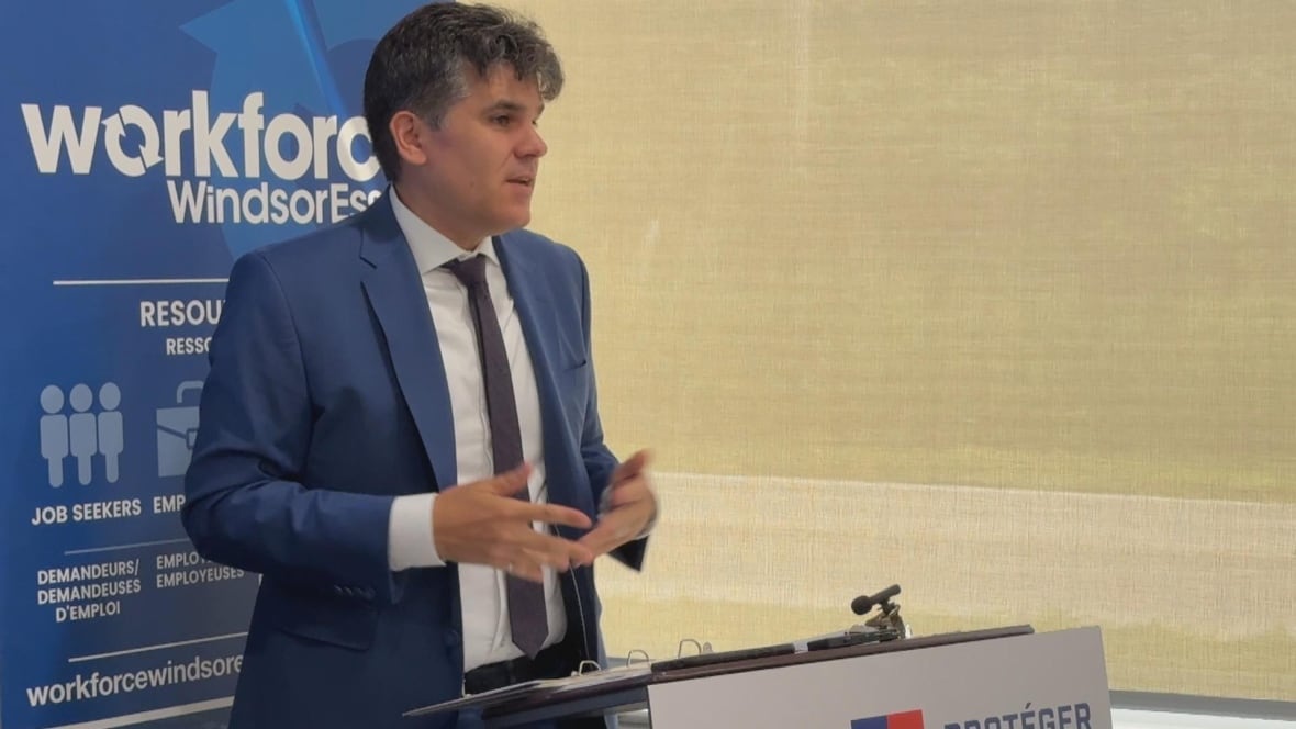 An MPP stands at a lectern. 