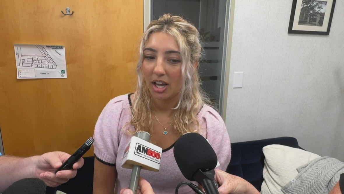 A woman is interview by a press scrum. 