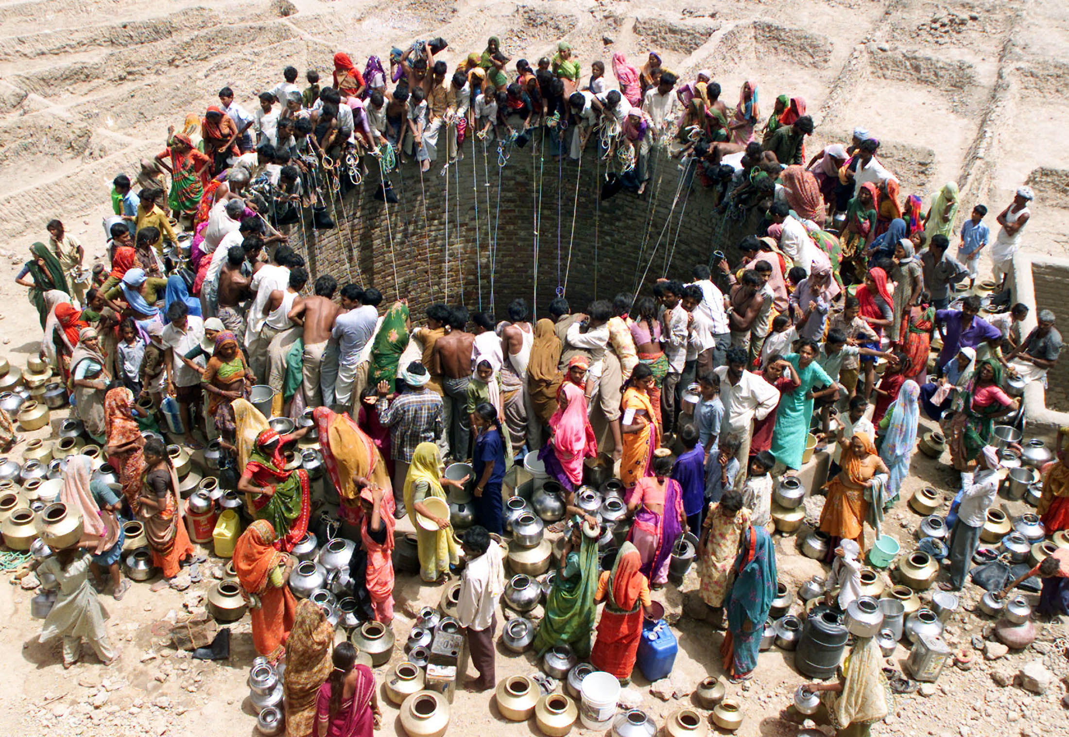 People gather to get water from a huge well in the village of Natwarghad