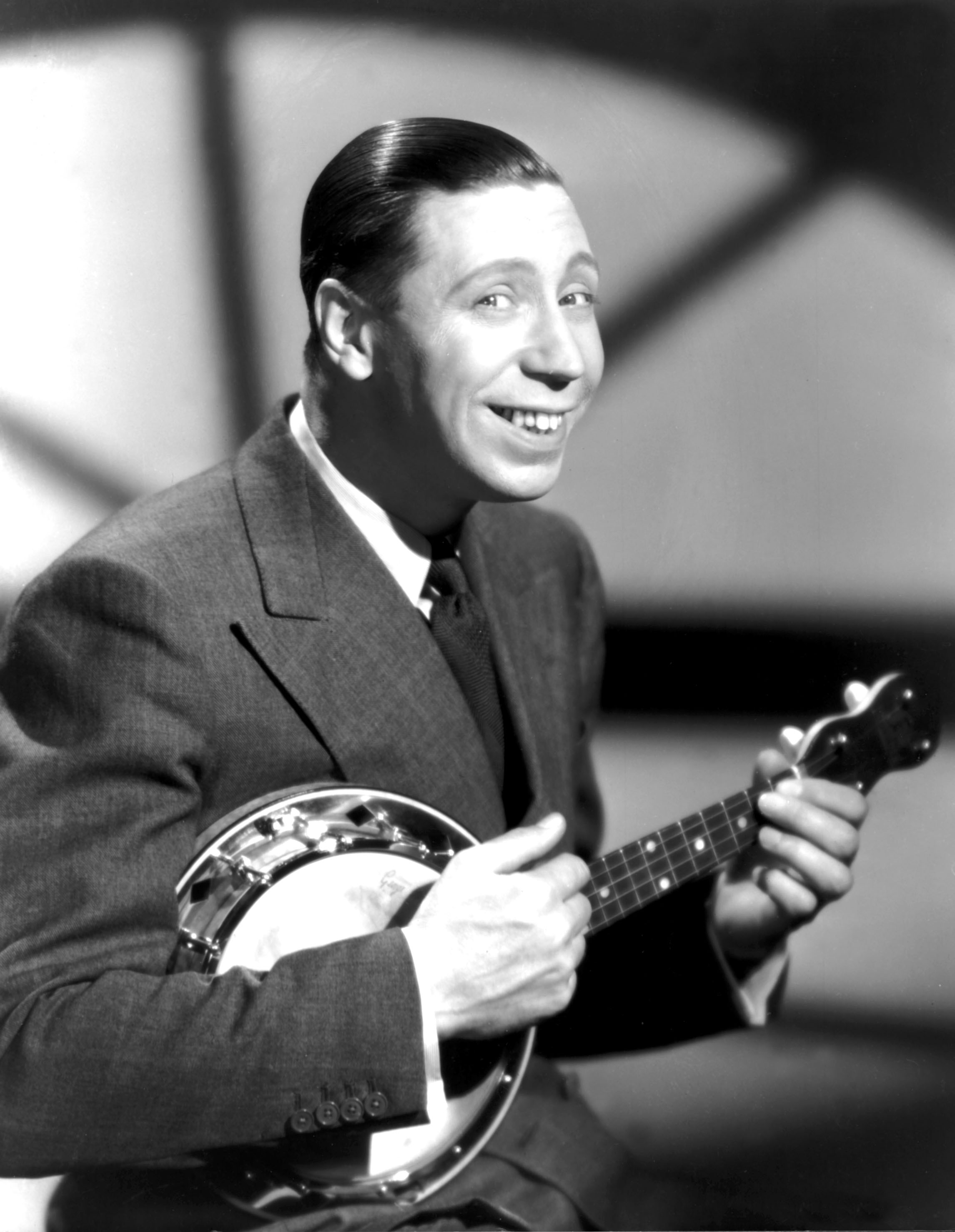 George Formby playing the ukulele.