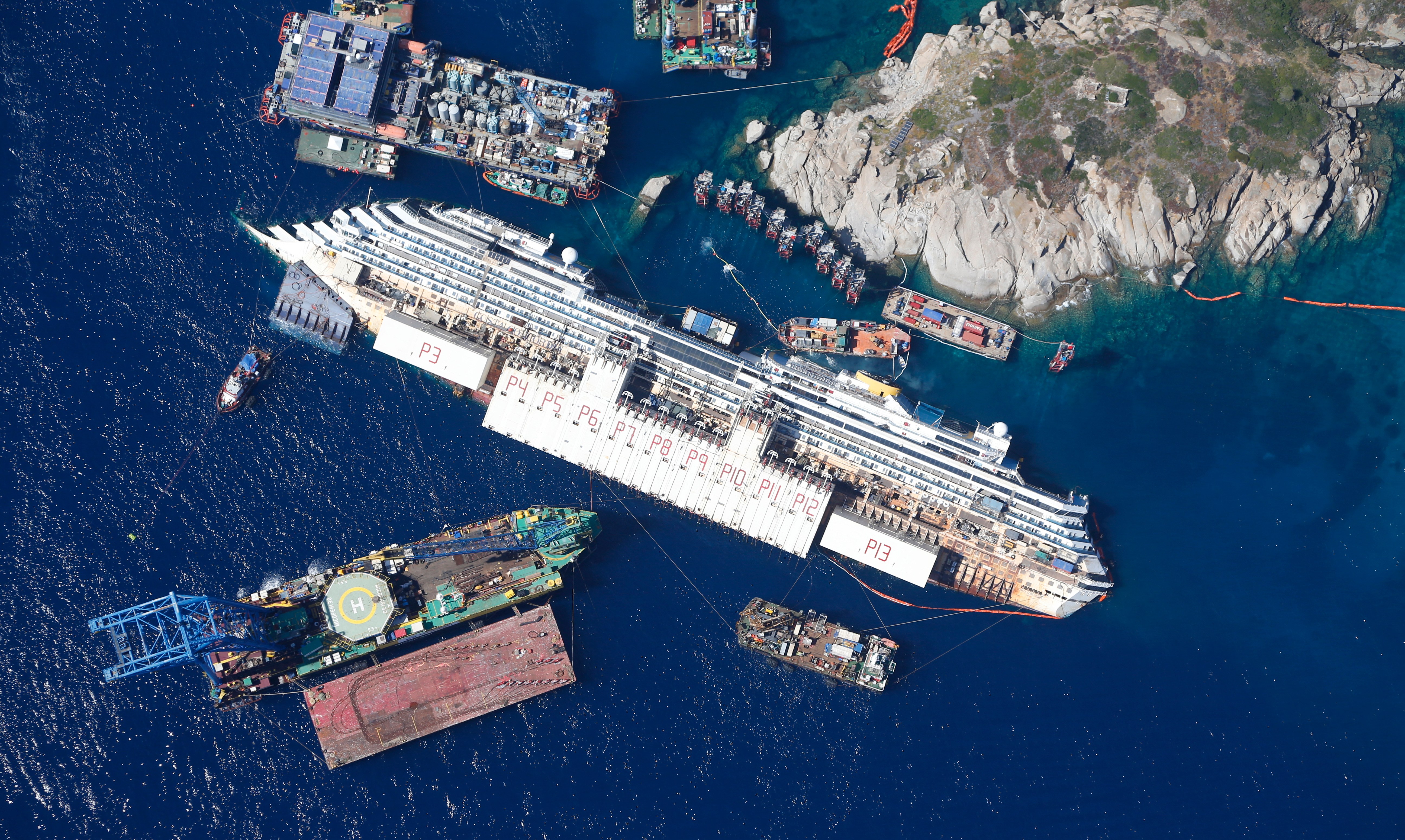 An aerial view shows the Costa Concordia as it lies on its side next to Giglio Island taken from an Italian navy helicopter