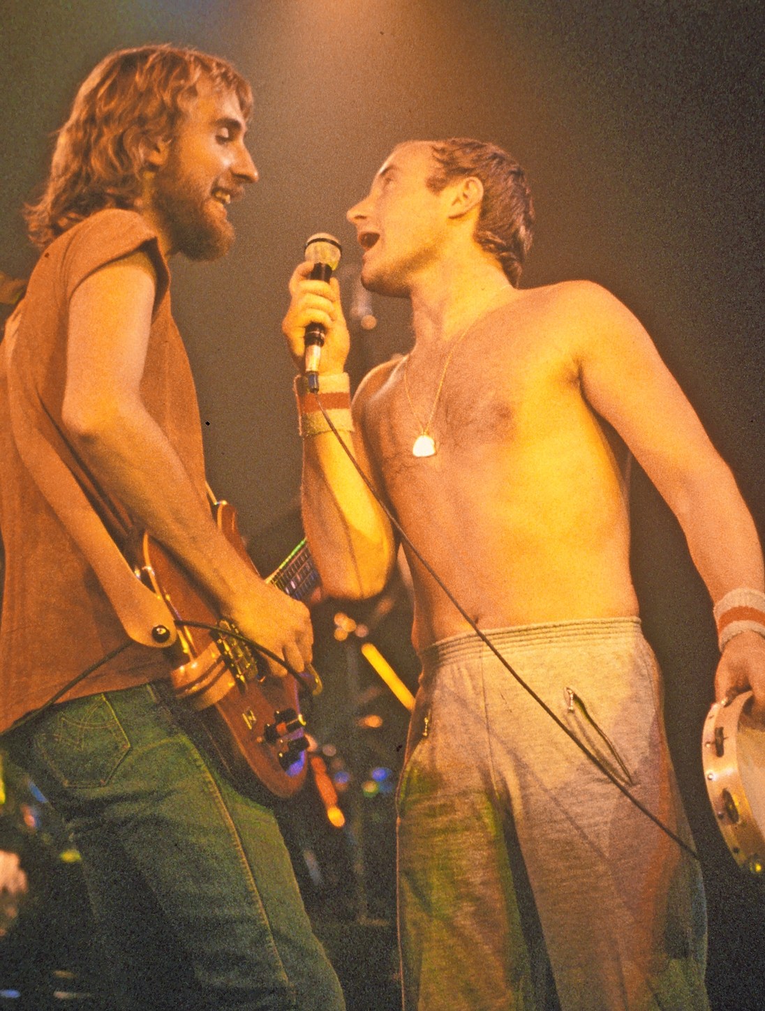 Genesis UK rock group with Mike Rutherford at left and Phil Collins on stage.