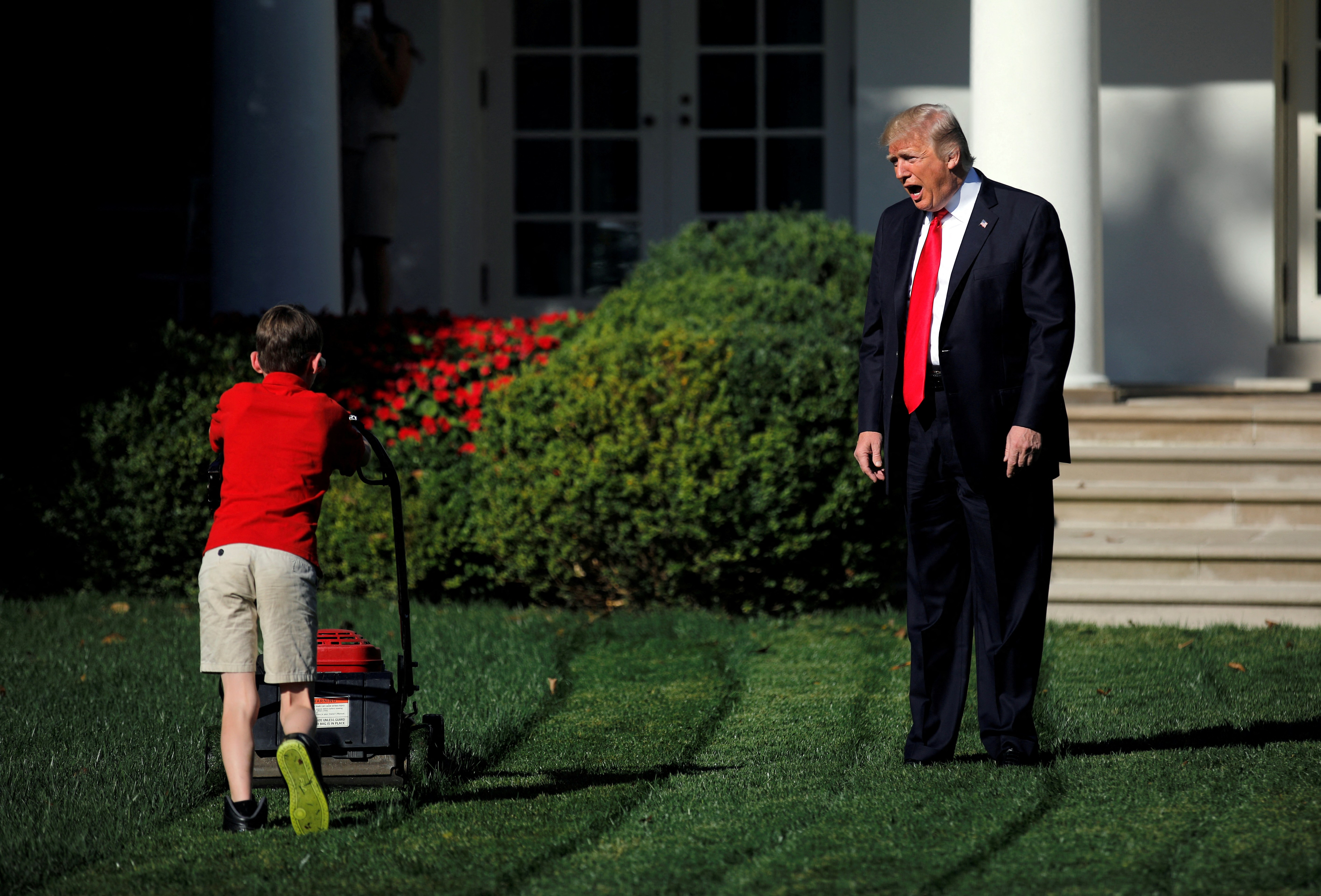 U.S. President Donald Trump welcomes 11-year-old Frank Giaccio as he cuts the Rose Garden grass at the White House in Washington