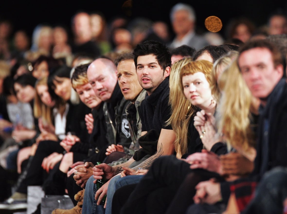A row of people look on at a fashion show in New Zealand.