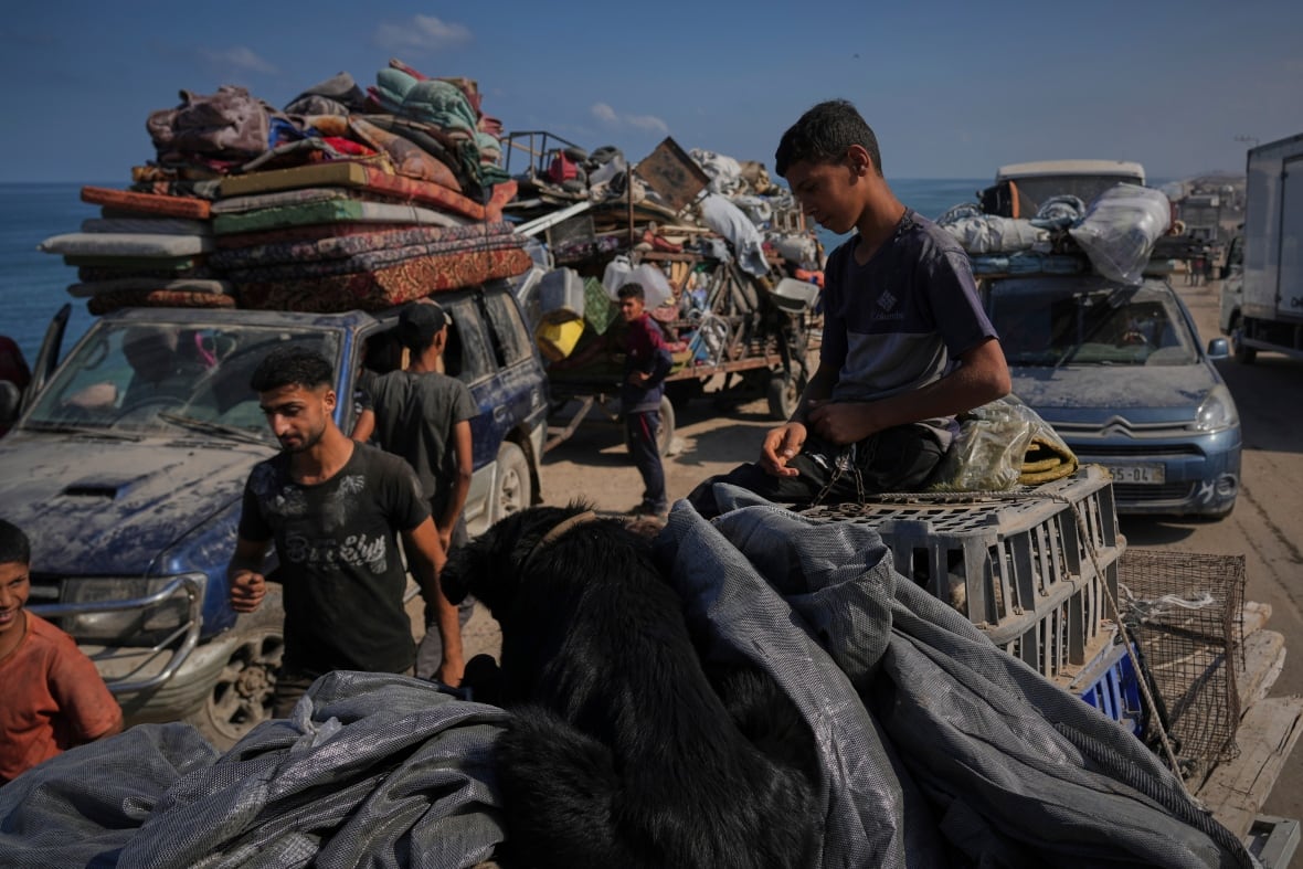 Men and boys stand near packed cars fleeing the violence.