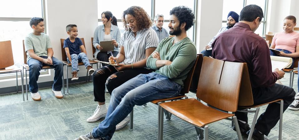 Large group of diverse people wait to see doctor