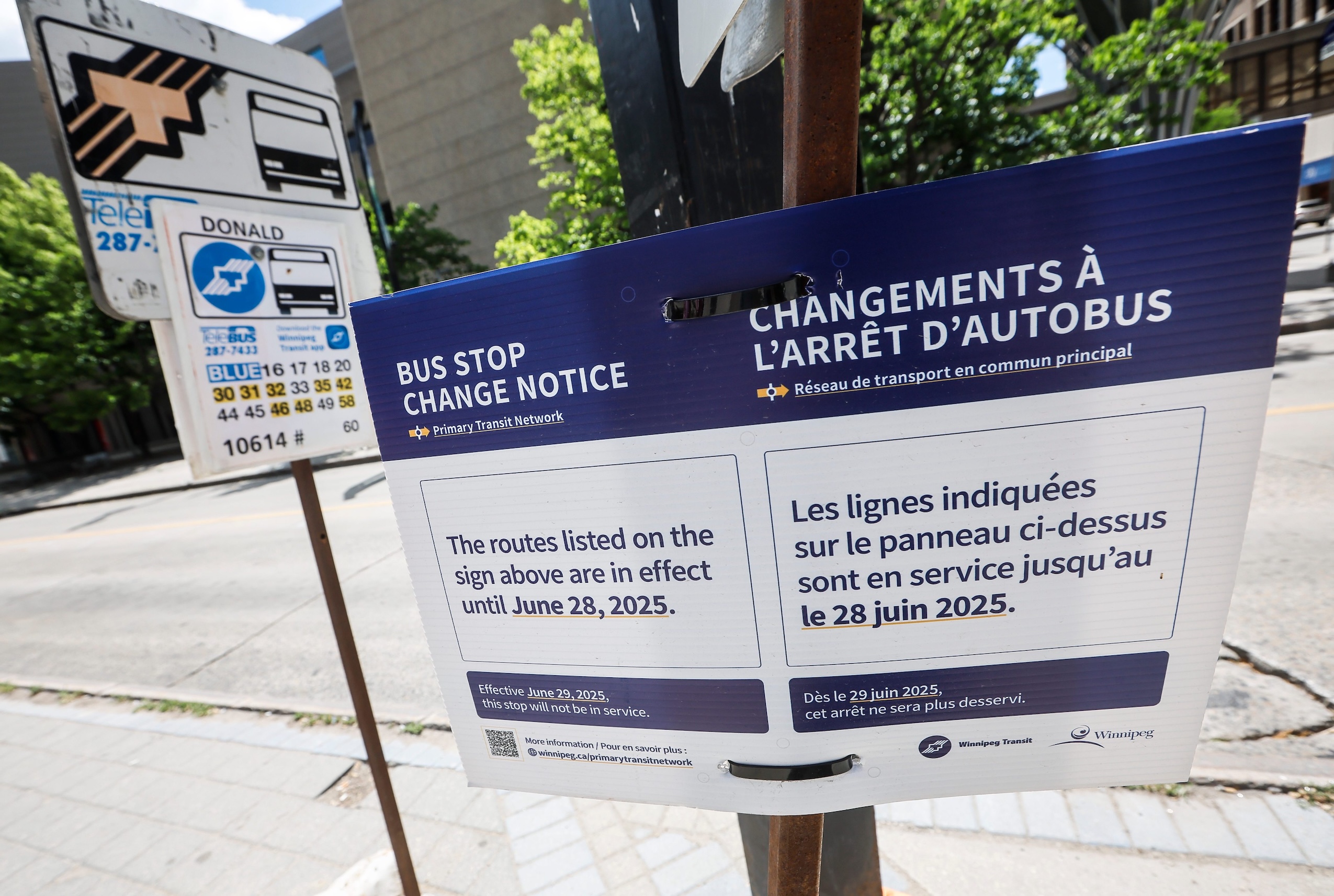A temporary sign at an old Winnipeg Transit stop reads: "The routes listed on the sign above are in effect until June 28, 2025." And notes the stop will not be in service following that date