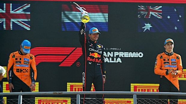 Max Verstappen lifts the winner's trophy high on the Italian Grand Prix podium.