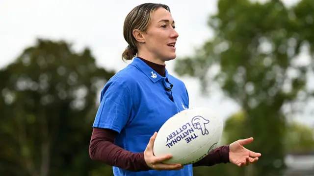 Lucy Bronze holding a rugby ball