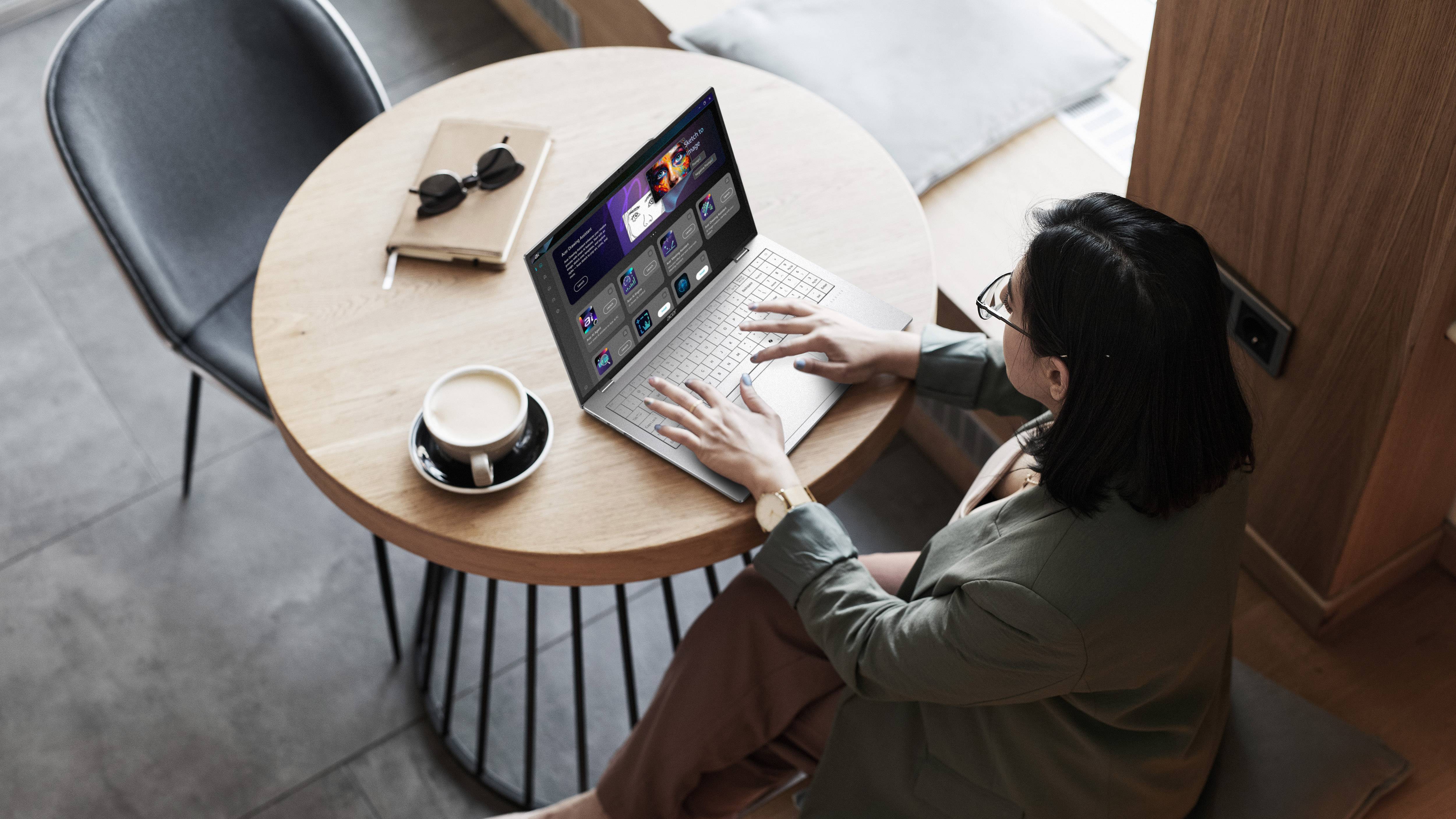 Person typing on Acer Swift Air 16 on table with coffee and glasses on table