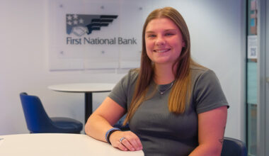 Morgan Woods sitting at a table in front of an FNB logo.