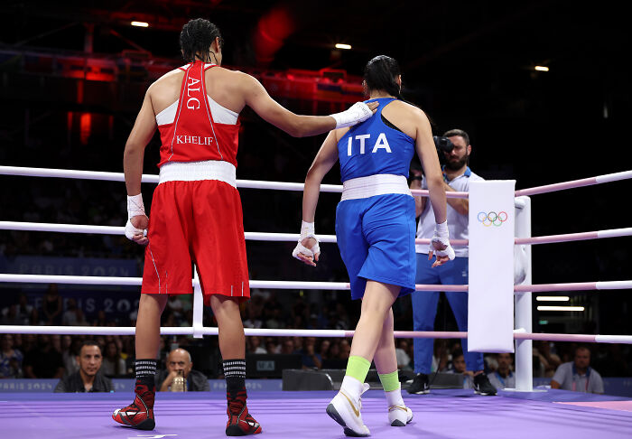 Two female boxers in the ring, one from Algeria and the other from Italy, highlighting harassment affecting a boxing career. Two female boxers in the ring, one from Algeria and the other from Italy, highlighting harassment affecting a boxing career.