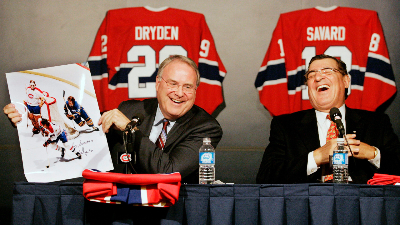 Serge Savard laughs as Ken Dryden shows a picture of the duo, with Buffalo Sabre Rick Martin during their playing days, at a news conference to announce the retirement of their sweater numbers in Montreal on Wednesday, September 20, 2006. The photograph shows Dryden in a relaxed pose despite the puck being played near his crease. (Ian Barrett/CP)