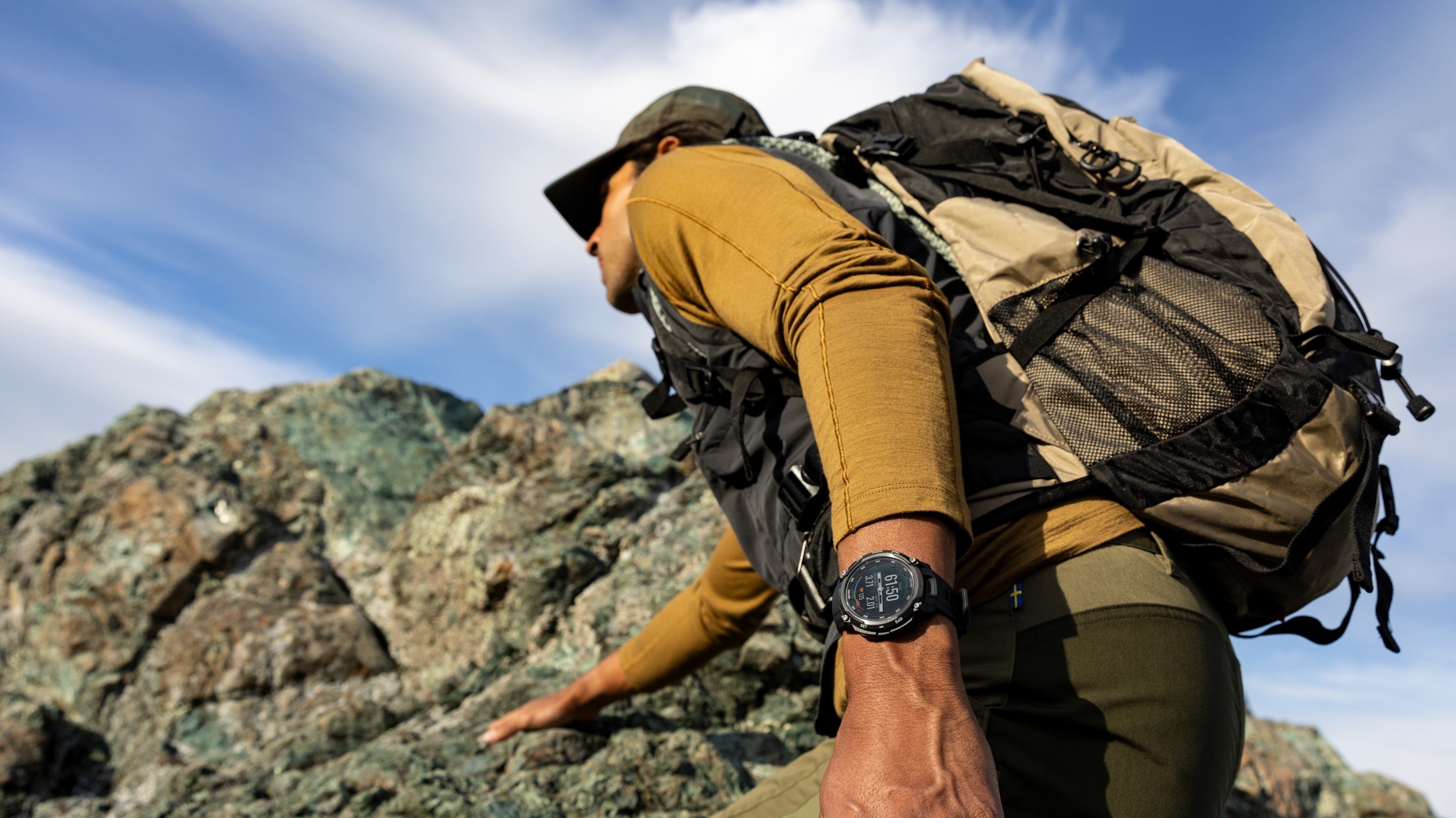 A photo of a person hiking with a heavy pack while wearing the Garmin Instinct Crossover AMOLED watch.
