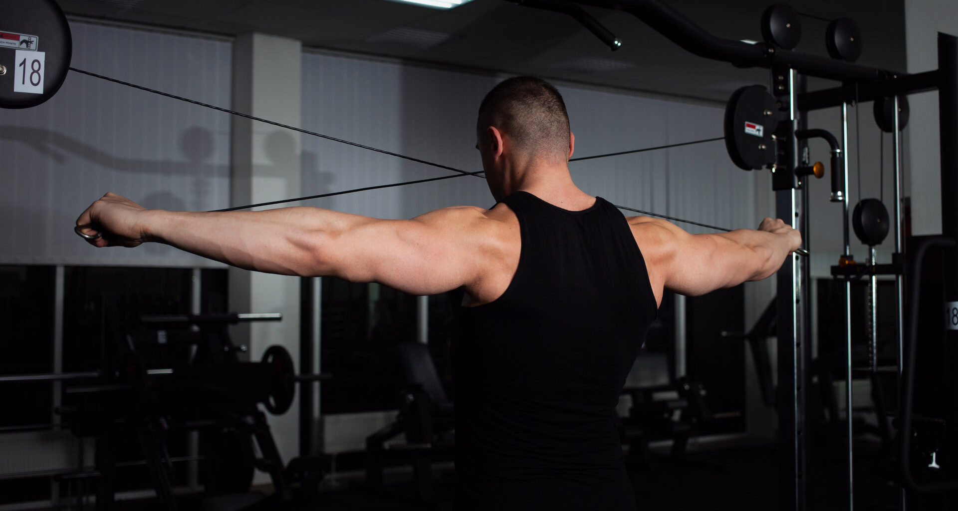 A man doing reverse cable flyes