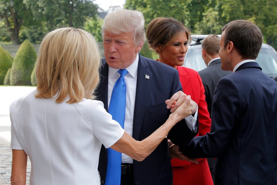 Four people in formal dress greet each other