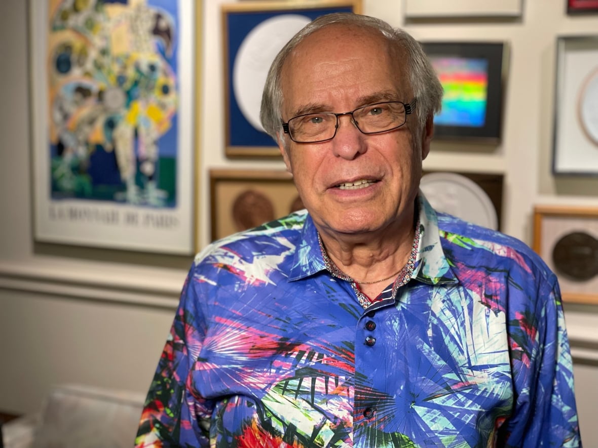 A portrait of Real Estate lawyer Bob Aaron in front of a gallery wall inside his downtown Toronto office.