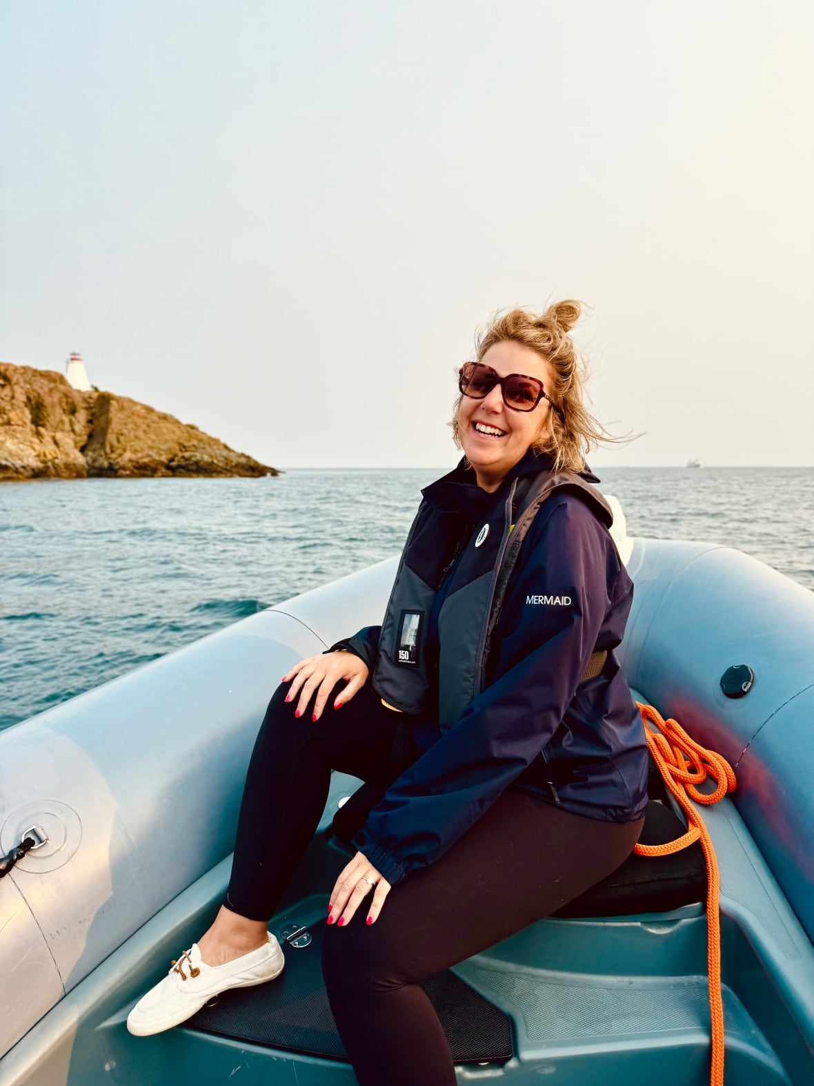 Woman on a boat in a life jacket whale watching. 