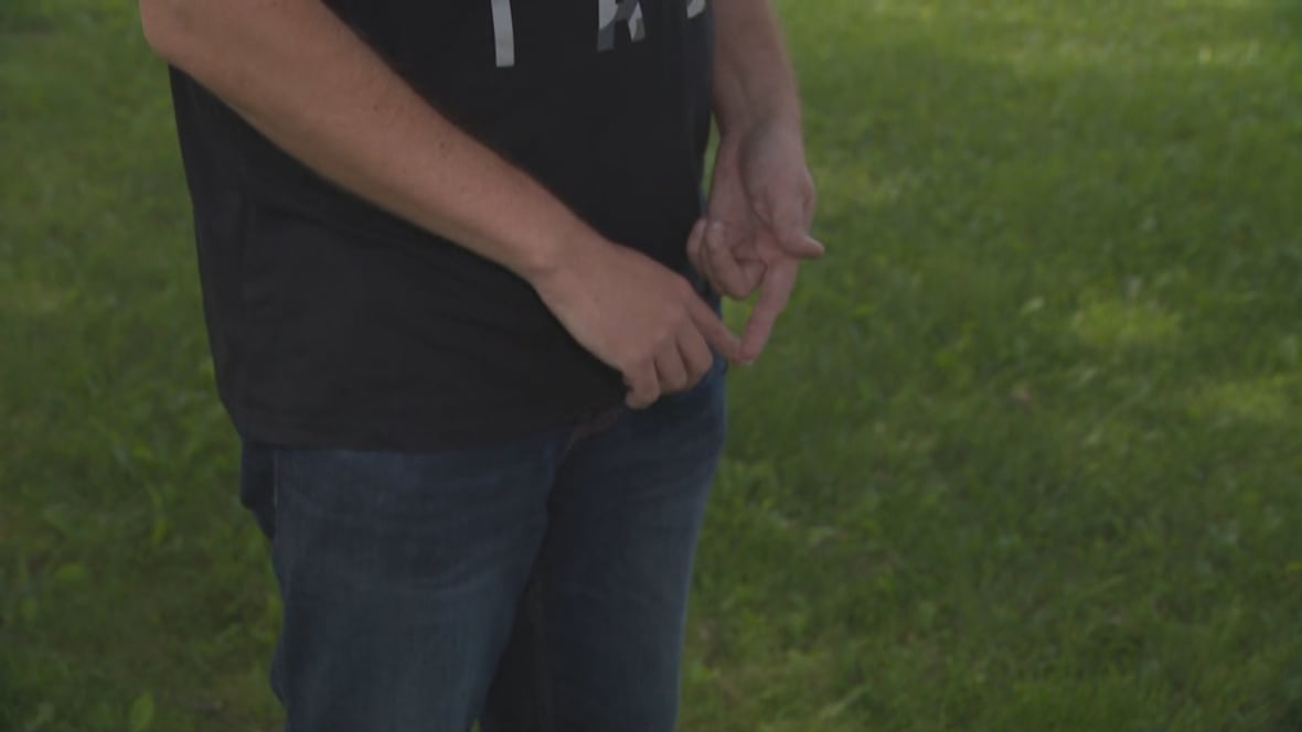 Picture of man standing on grass, hands only
