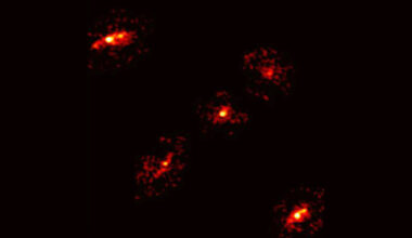 a pixelated image of five glowing blobs that form an 'X' shape