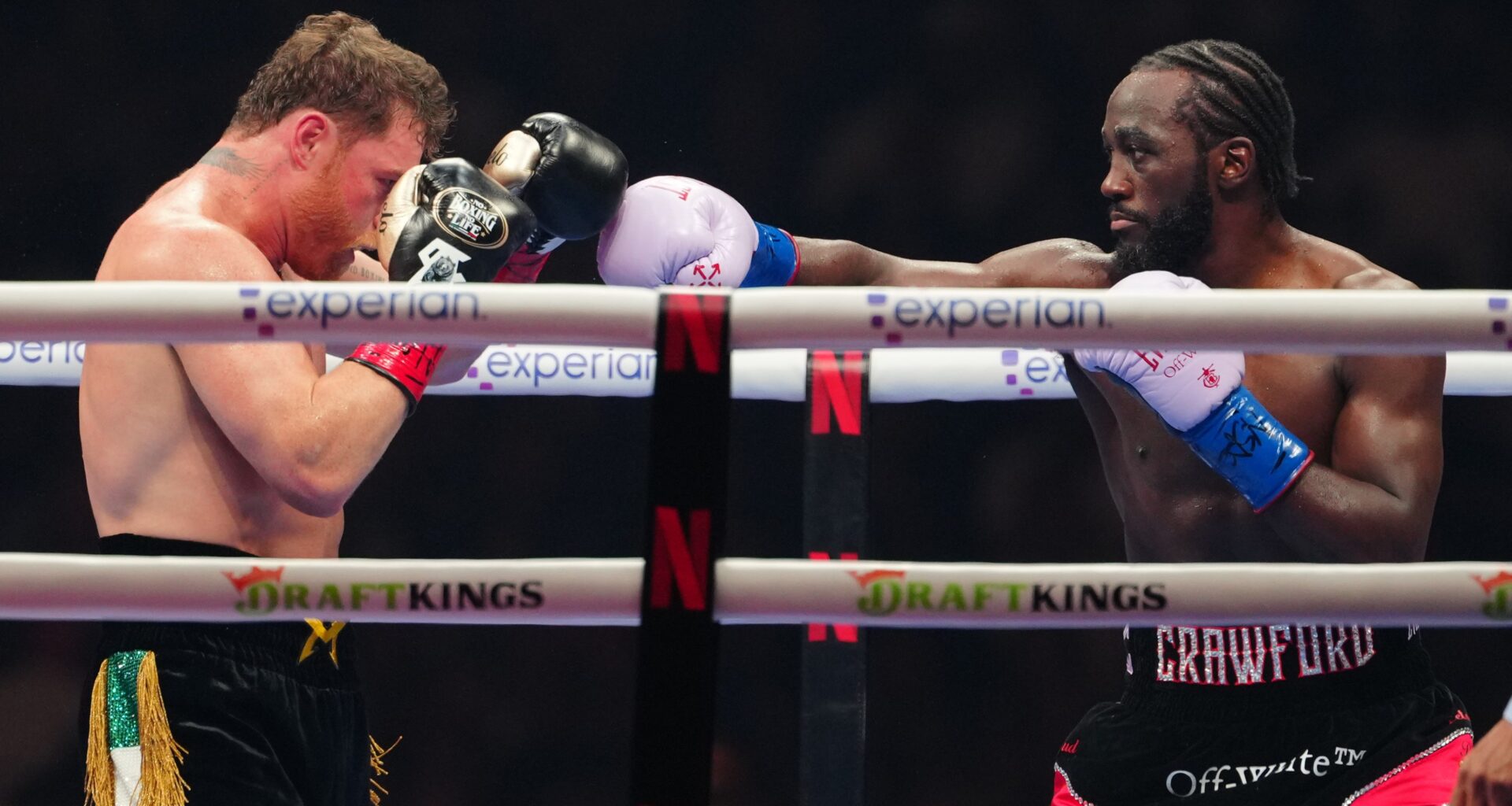 Terence Crawford punches Canelo Alvarez with his right arm boxing glove.