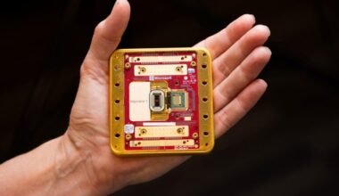 A hand on a black background holding up Microsoft’s Majorana 1 quantum computing chip