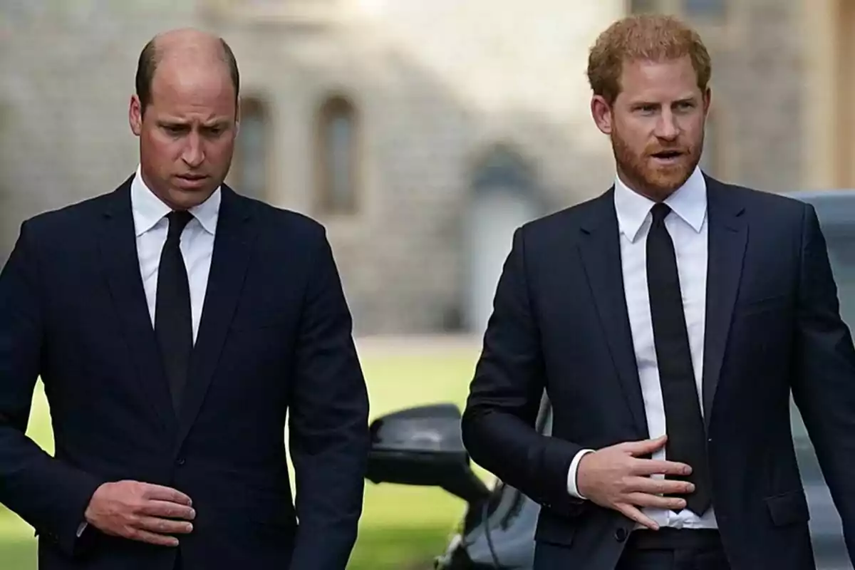 Two men dressed in dark suits and black ties walking outdoors. Two men dressed in dark suits and black ties walking outdoors.
