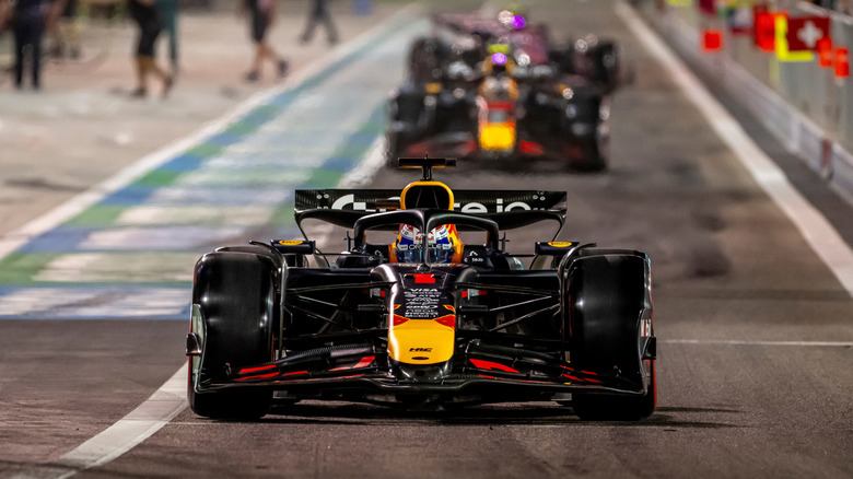 Formula 1 cars lining up on a race track.