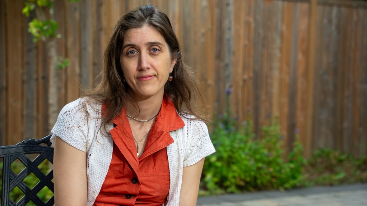 a woman sitting outside  on a bench. 
