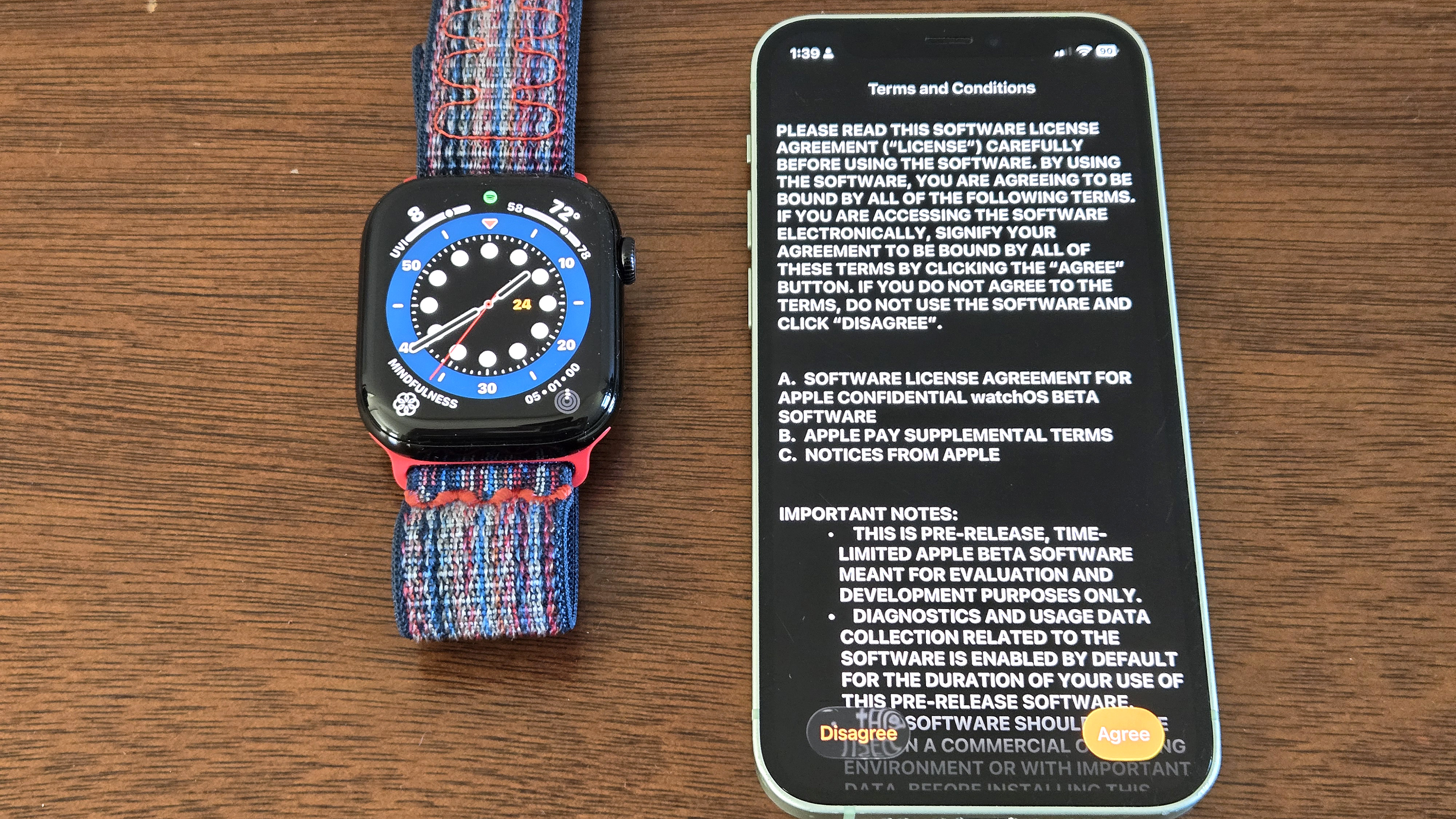 Close-up of the installation process for watchOS 26 showing an Apple Watch Series 10 and iPhone 12 Mini