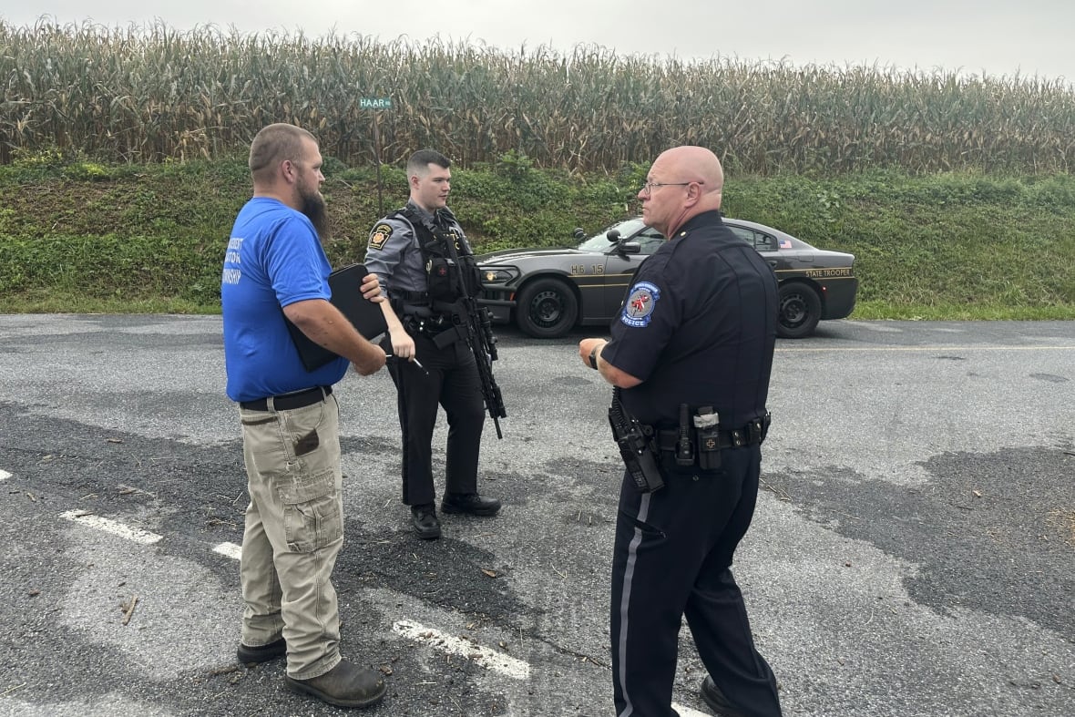Police stand near a crime scene.