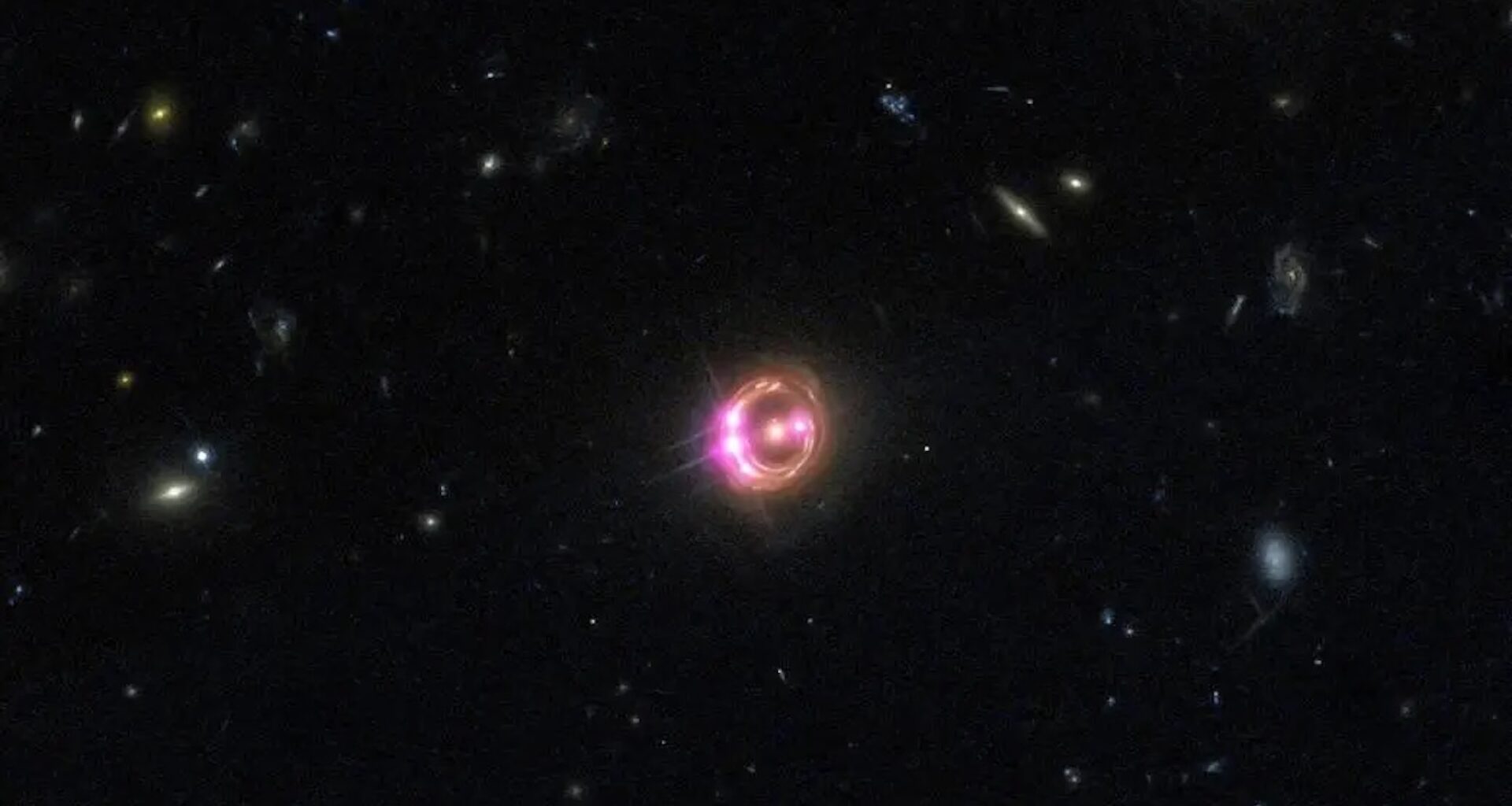 An image of a glowing orange and purple halo in outer space