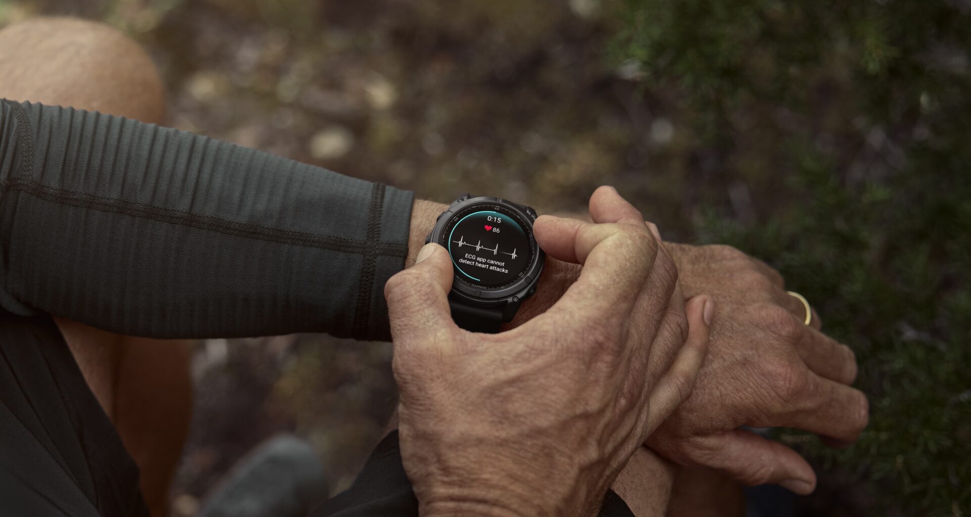A photo of a man in the woods wearing a Garmin Fenix 8 Pro, using it to check his ECG heart health data.