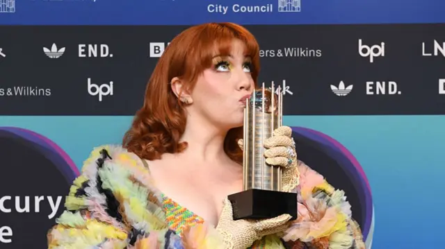 Irish singer CMAT kissing the Mercury Prize award at the 2025 ceremony in Newcastle