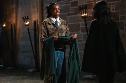 Cat Burns receives her Traitors' cloak from Claudia Winkelman