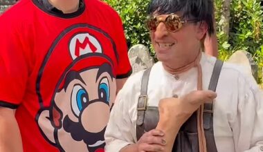 David Habour stops for a picture with a fan while wearing a red Mario T-shirt during a day out at the Epic Universe theme park in Orlando, Florida, with Lily Allen's daughters