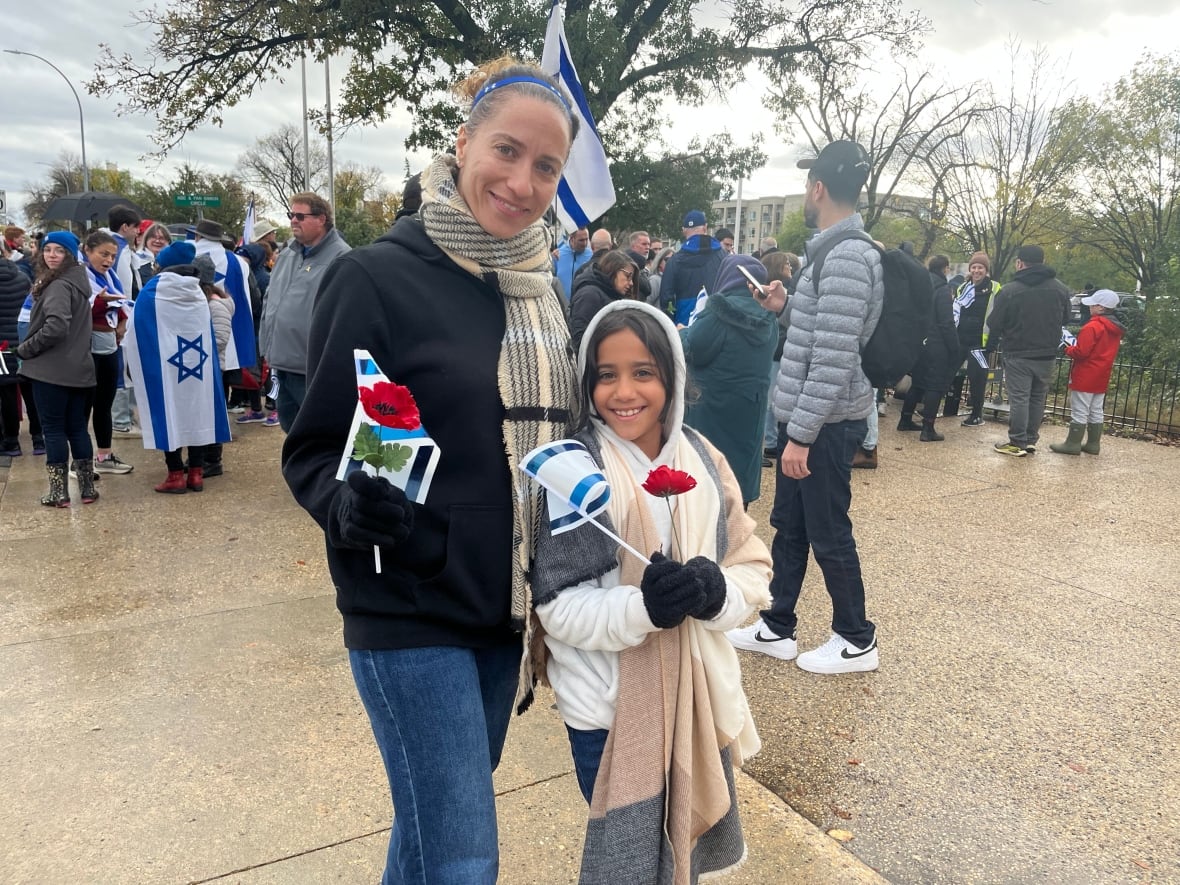 A woman in a black shirt standing next to a child. 